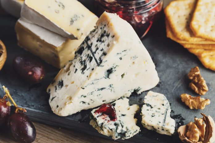Different arts of cheese with grape on wooden