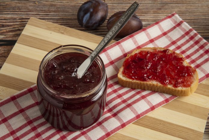 Plums with a jar of confiture and a toast bread