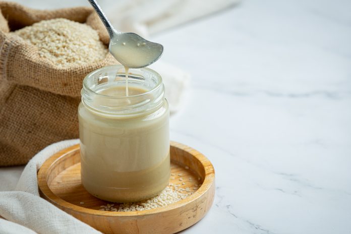 tahini and sesame seeds on marble background