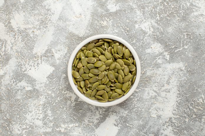 top-view-green-seeds-from-pumpkin-white-background-seed-green-photo