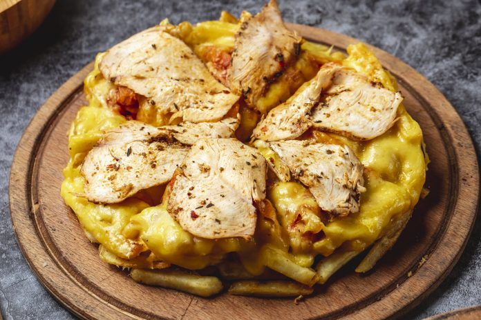 side view french fries pizza with melted cheese roasted chicken and seasoning on a board