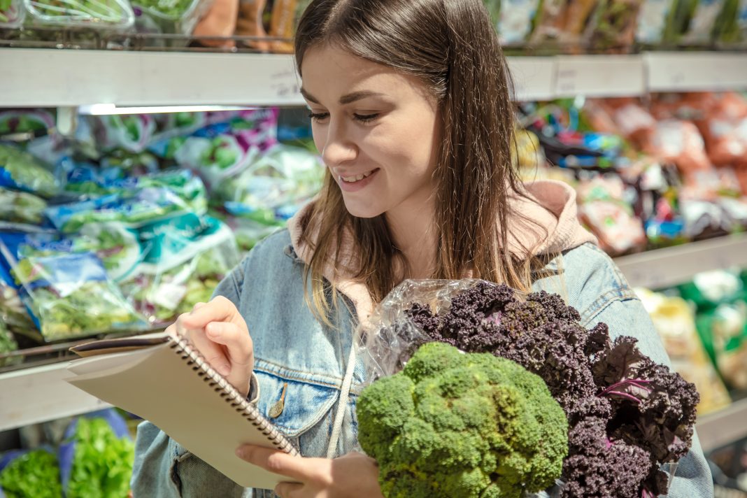 young-woman-with-notebook-buys-groceries-supermarket