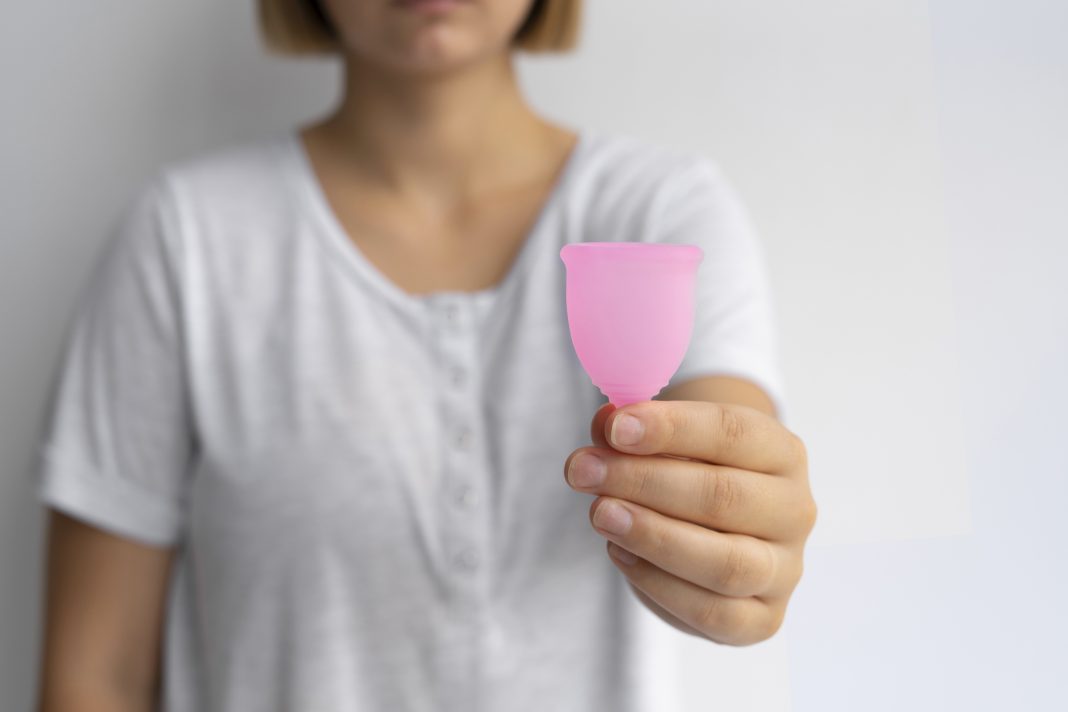 front-view-woman-holding-pink-menstrual-cup