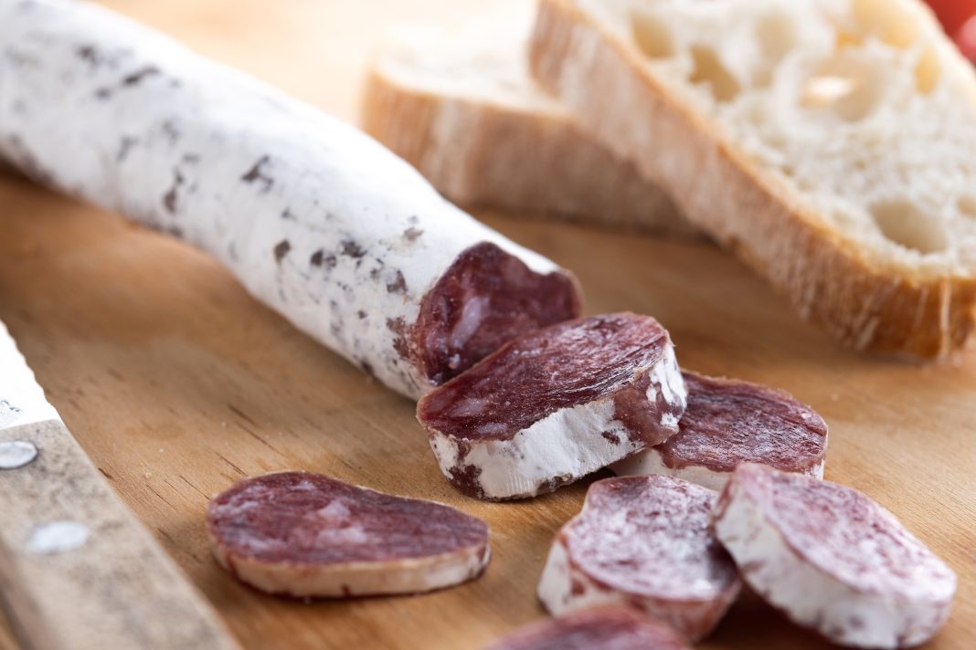 Fuet.Dry cured fuet sausage on wooden table