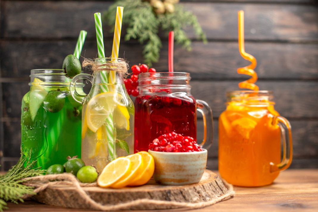 side-view-organic-fresh-juices-bottles-served-with-tubes-fruits-wooden-cutting-board
